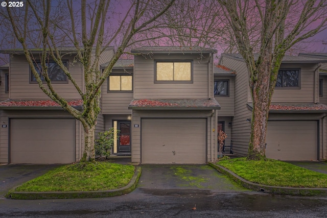 view of property featuring a garage and aphalt driveway