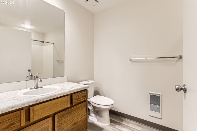 bathroom featuring visible vents, toilet, wood finished floors, heating unit, and vanity