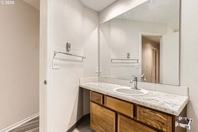 bathroom featuring wood finished floors, vanity, and baseboards