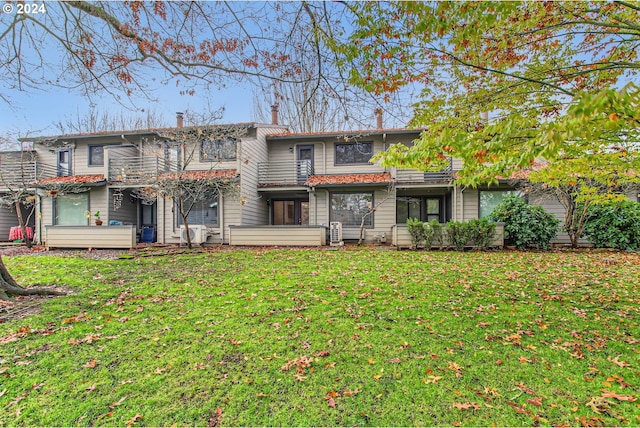 view of front of home featuring a balcony and a front lawn