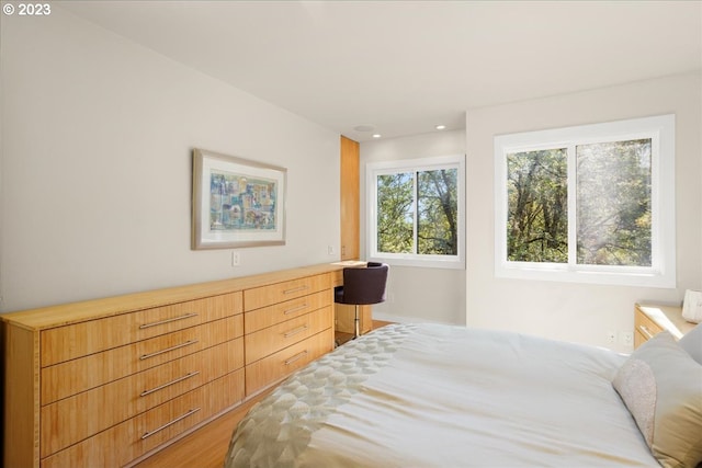 bedroom featuring hardwood / wood-style floors and built in desk