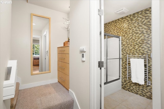 bathroom with tile patterned flooring and shower / bath combination with glass door