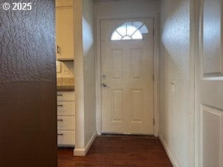 doorway to outside with dark wood-style floors and baseboards