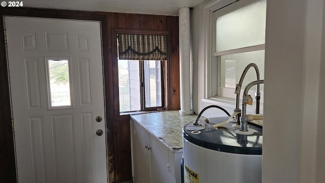 interior space featuring gas water heater, plenty of natural light, and ornate columns