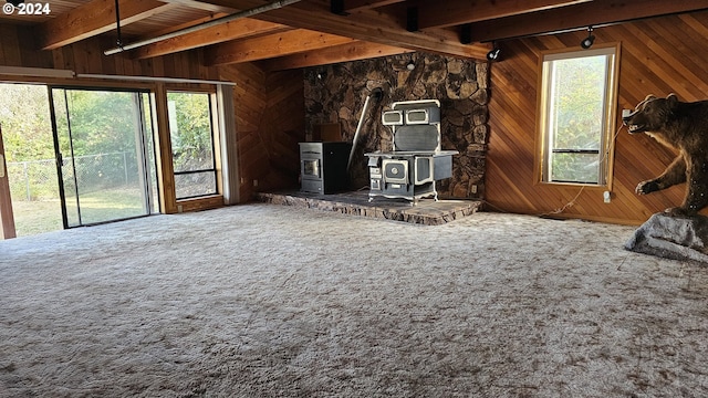 miscellaneous room with carpet flooring, wooden walls, beam ceiling, and a wood stove