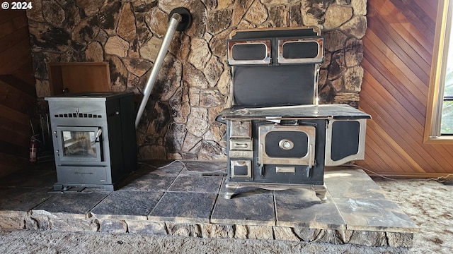 room details with heating unit, wooden walls, and a wood stove