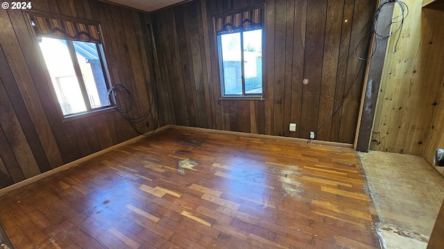 spare room featuring wooden walls and hardwood / wood-style flooring