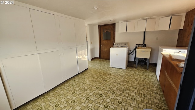 clothes washing area featuring washer / clothes dryer and cabinets