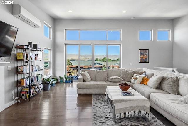 living room with dark hardwood / wood-style flooring, an AC wall unit, plenty of natural light, and a mountain view