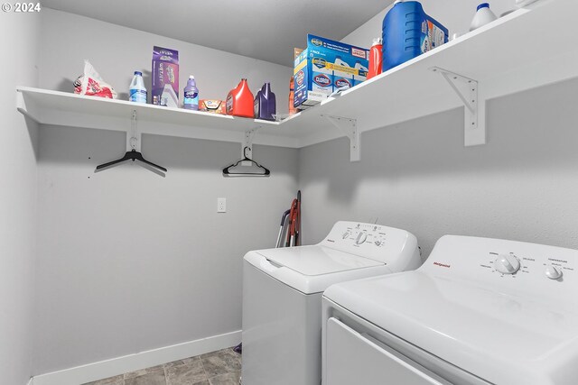 laundry area with independent washer and dryer and light tile patterned floors