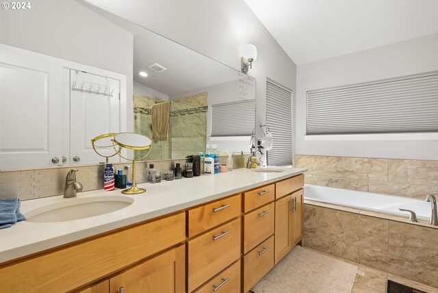 bathroom with vanity, tile patterned flooring, lofted ceiling, and plus walk in shower