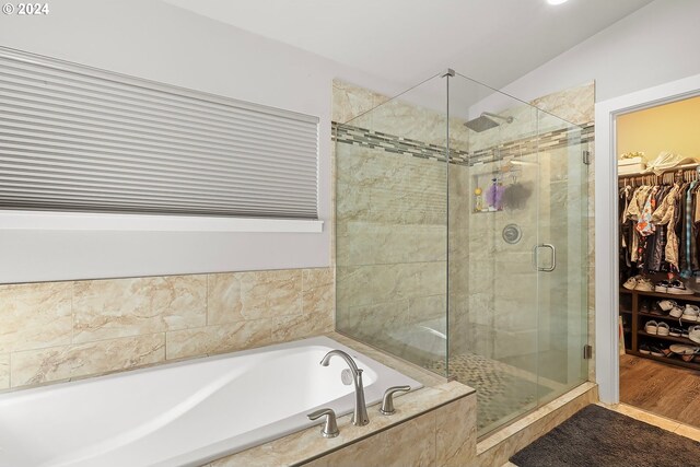 bathroom with shower with separate bathtub, vaulted ceiling, and hardwood / wood-style flooring