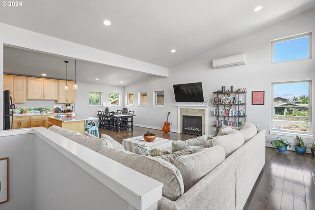 living room featuring a wall unit AC, a tile fireplace, dark hardwood / wood-style floors, and vaulted ceiling