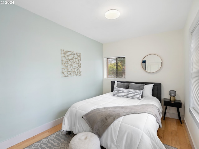 bedroom with baseboards and wood finished floors