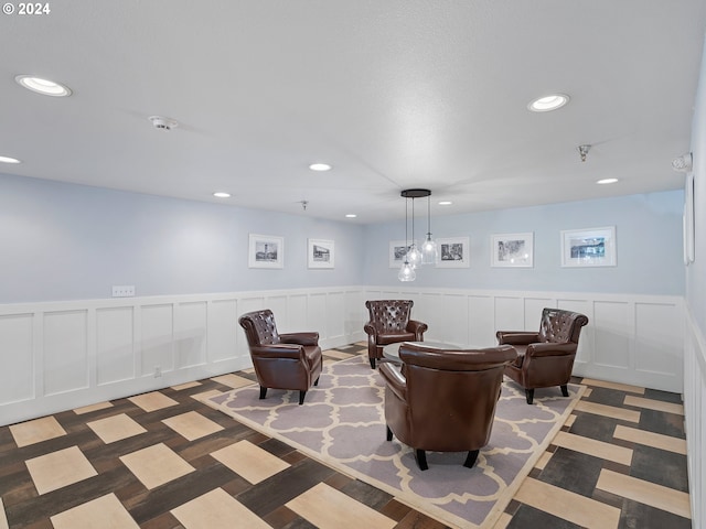 living area with recessed lighting, a wainscoted wall, and a decorative wall