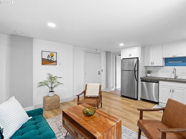 living room with light hardwood / wood-style flooring and sink