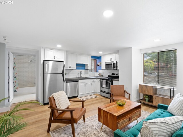 living room with light hardwood / wood-style flooring and sink