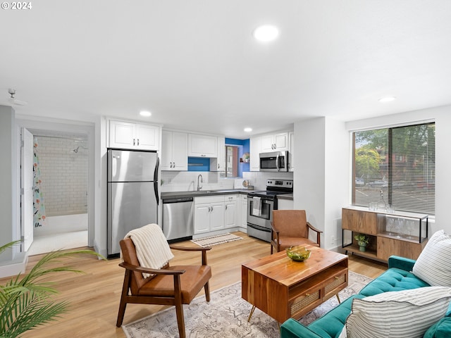 living area with light wood-type flooring and recessed lighting