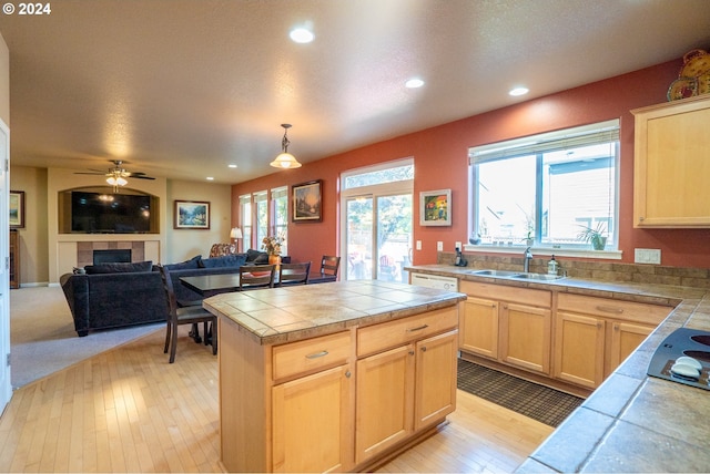 kitchen featuring pendant lighting, tile counters, and light brown cabinetry