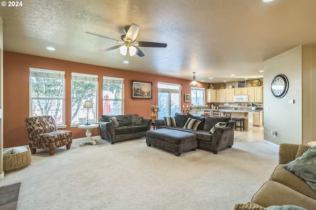 carpeted living room with a textured ceiling and ceiling fan