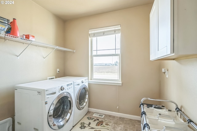 laundry room with washing machine and dryer and cabinets