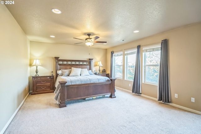 carpeted bedroom with ceiling fan and a textured ceiling