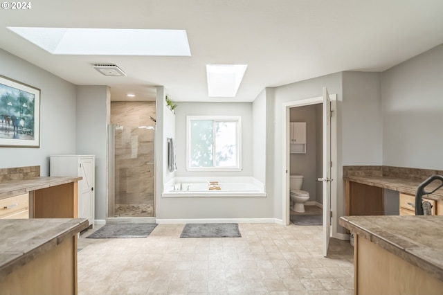 full bathroom featuring vanity, a skylight, plus walk in shower, and toilet