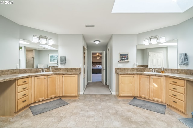 bathroom featuring vanity and a skylight