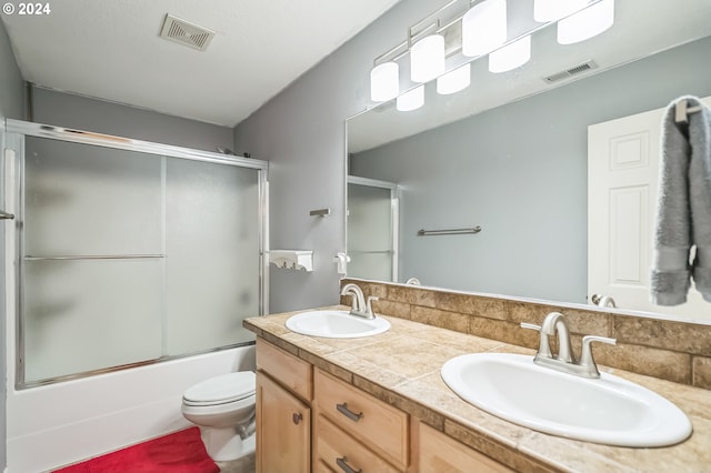 full bathroom with shower / bath combination with glass door, vanity, and toilet