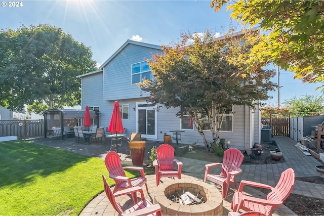 rear view of house featuring a lawn, a patio, and an outdoor fire pit