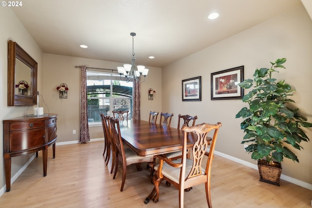 dining area with light wood-type flooring and a chandelier