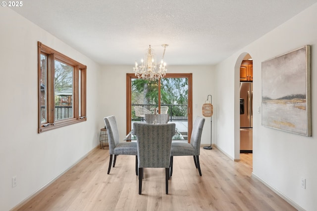 4243 Spring Rock Cir, West Linn, OR 97068 - dining area with arched walkways, healthy amount of natural light, light wood-type flooring, and a textured ceiling