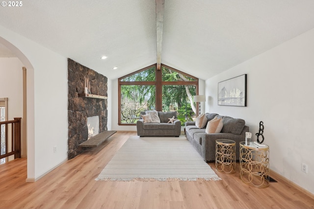 4243 Spring Rock Cir, West Linn, OR 97068 - living area featuring arched walkways, wood finished floors, and a stone fireplace