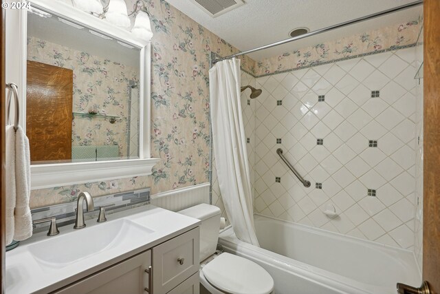 full bathroom featuring vanity, toilet, a textured ceiling, and shower / bathtub combination with curtain