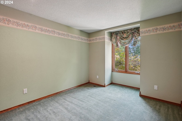 carpeted empty room with a textured ceiling