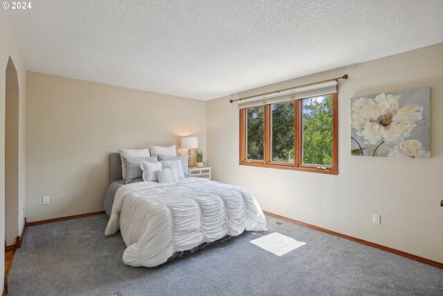 carpeted bedroom featuring a textured ceiling