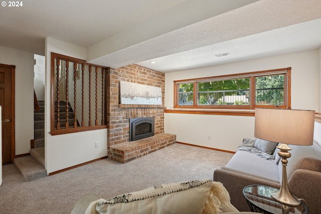 carpeted living room featuring a fireplace and a textured ceiling