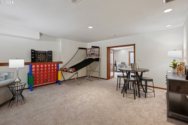 dining space with light carpet and a textured ceiling