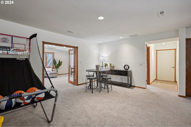 playroom with light carpet and a textured ceiling