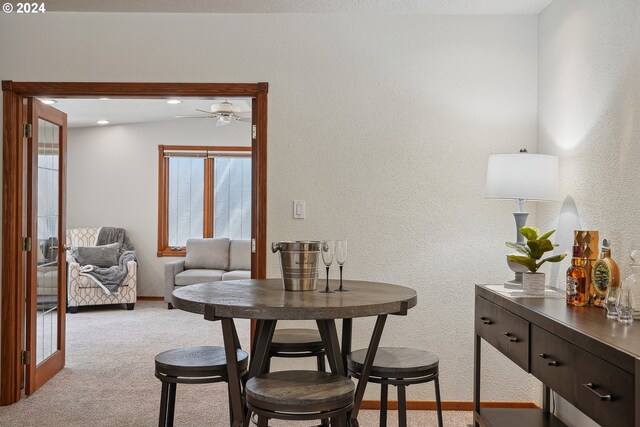 dining room featuring ceiling fan and light colored carpet