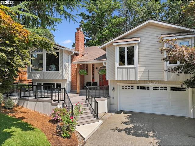 4243 Spring Rock Cir, West Linn, OR 97068 - view of front of property featuring a porch, a chimney, a garage, concrete driveway, and stairs