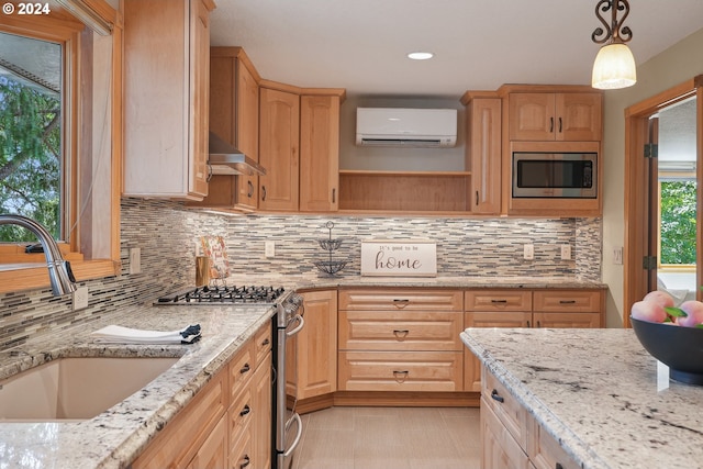 kitchen featuring sink, a wall mounted air conditioner, decorative light fixtures, stainless steel appliances, and light stone countertops