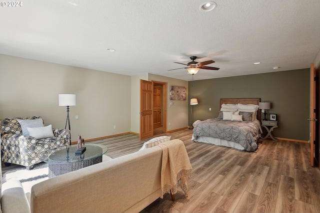 bedroom with hardwood / wood-style floors, a textured ceiling, and ceiling fan