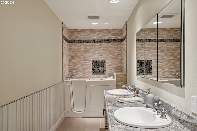 bathroom featuring vanity, tile patterned floors, and a bathing tub