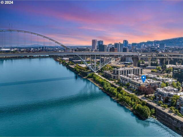 aerial view at dusk featuring a water view