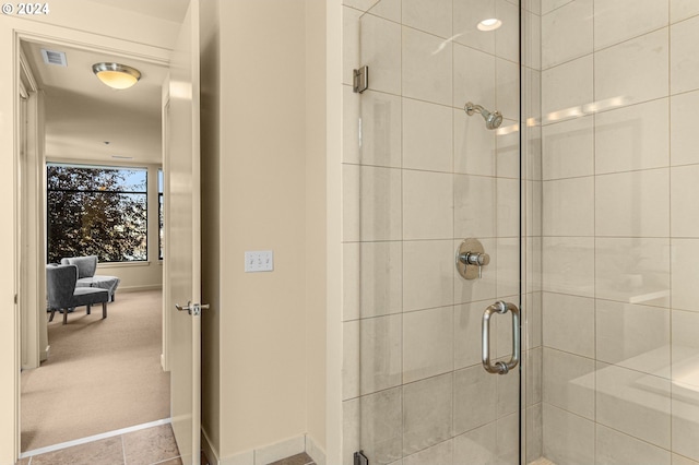 bathroom with a shower stall, visible vents, and baseboards