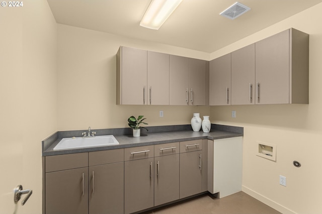 clothes washing area with washer hookup, cabinet space, a sink, and visible vents