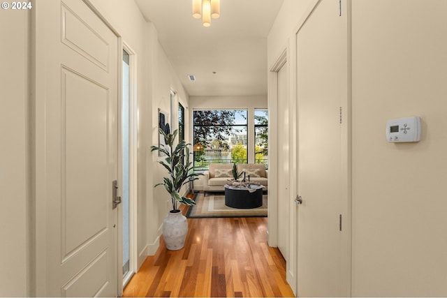 corridor with light wood-style flooring and baseboards