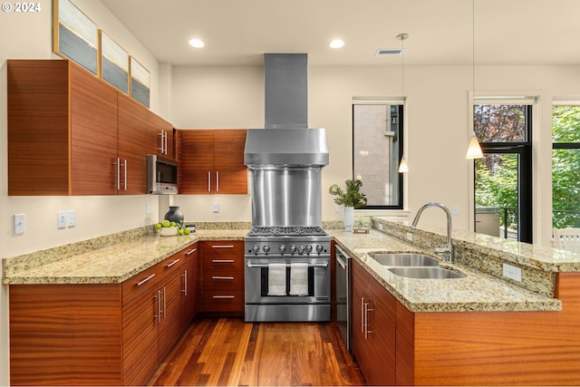 kitchen with visible vents, dark wood finished floors, a peninsula, stainless steel appliances, and a sink