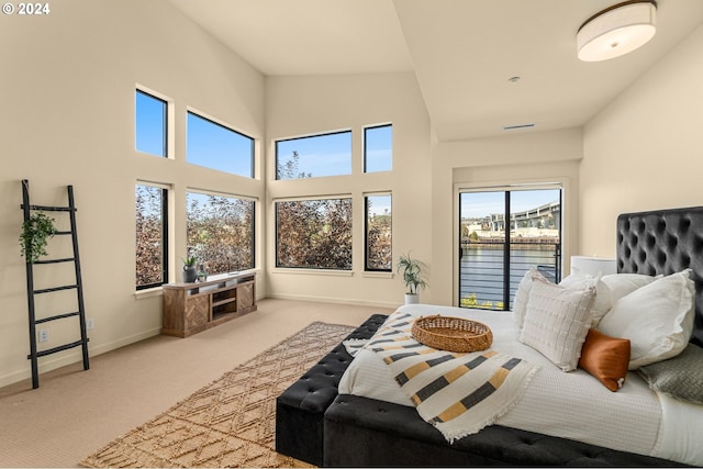 carpeted bedroom with visible vents, a towering ceiling, and baseboards